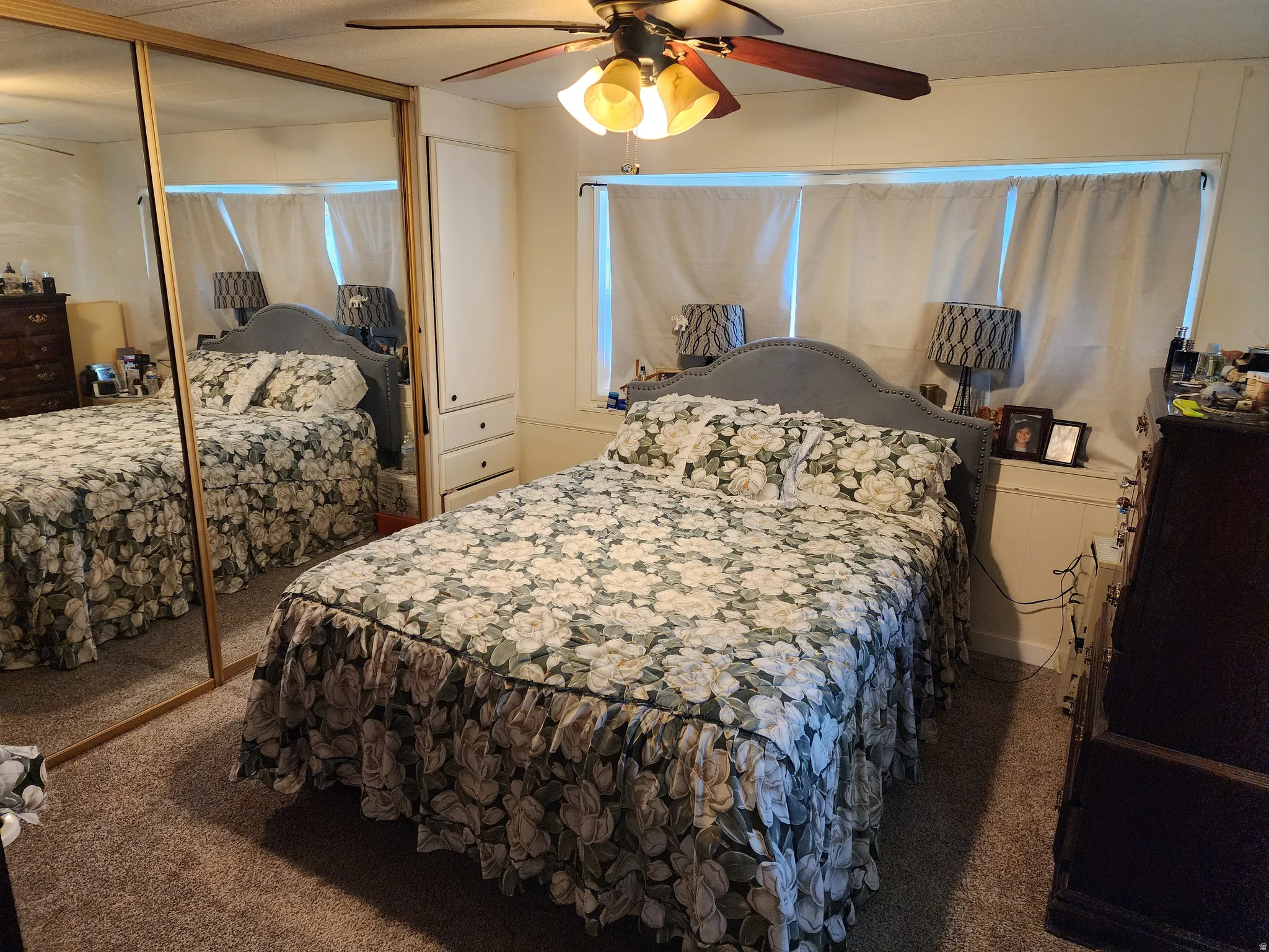 Carpeted bedroom with a closet and ceiling fan