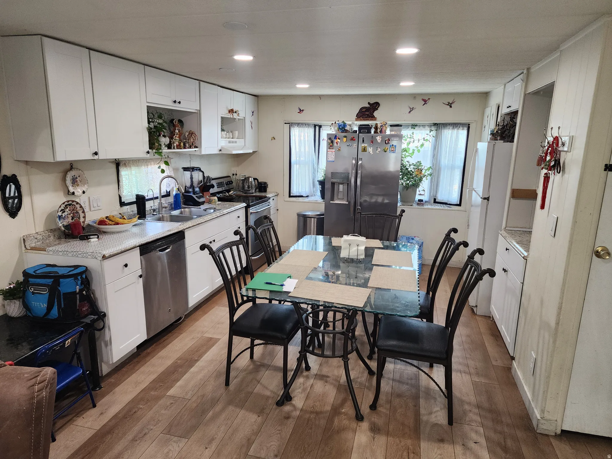Kitchen with white cabinetry, stainless steel appliances, light wood-style floors, open shelves, and recessed lighting
