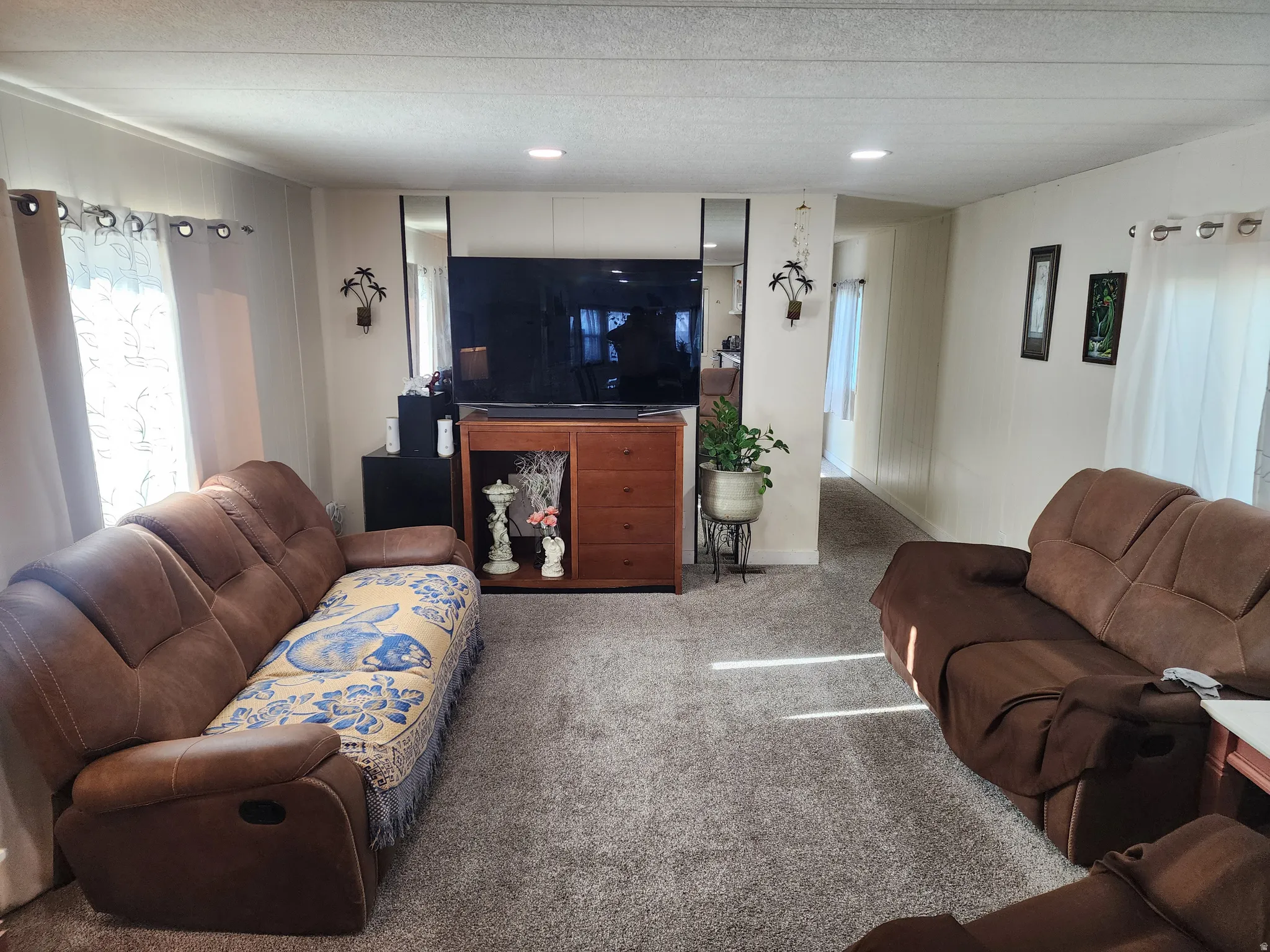 Carpeted living room with a textured ceiling