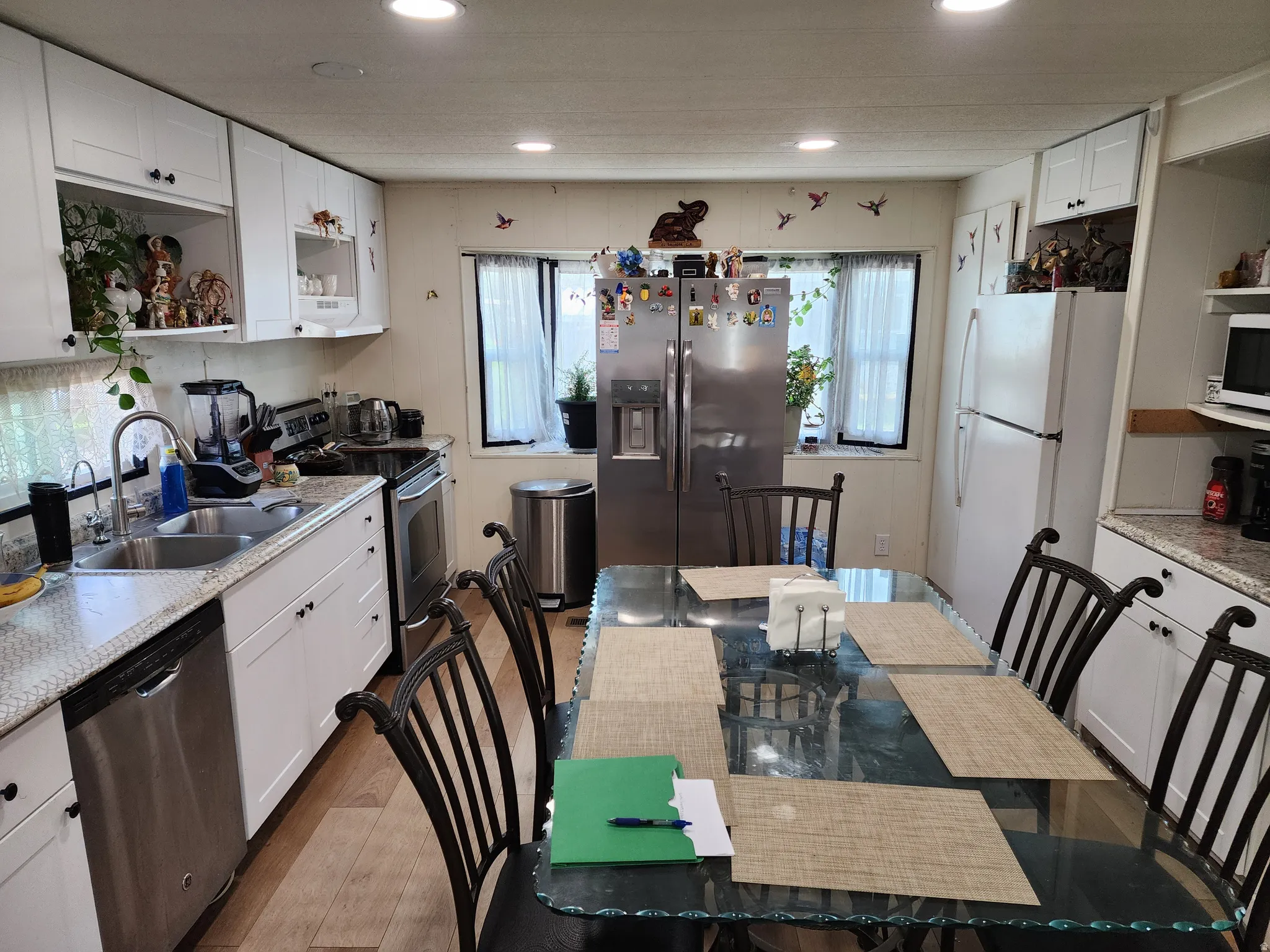 Kitchen with open shelves, white cabinetry, stainless steel appliances, wood finished floors, and recessed lighting