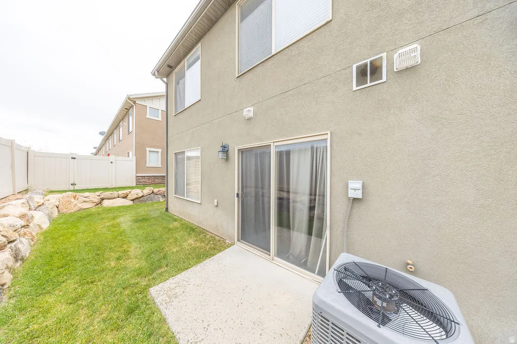 Rear exterior featuring a concrete patio and sliding glass door