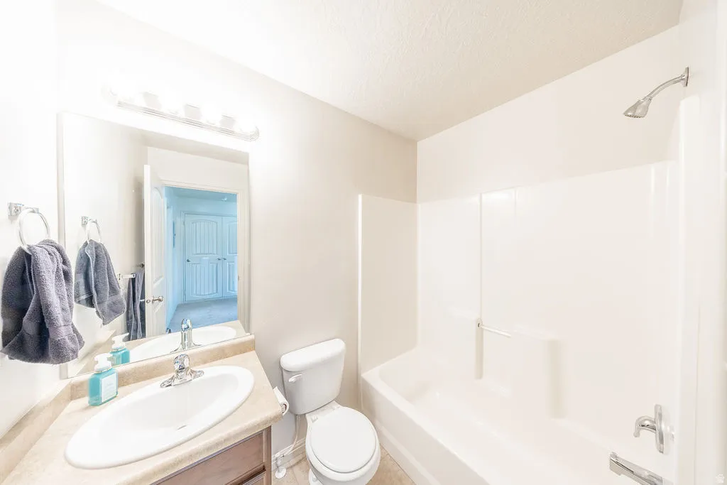 Main bathroom featuring a single vanity with a laminate countertop, an oval undermount sink, and a chrome faucet