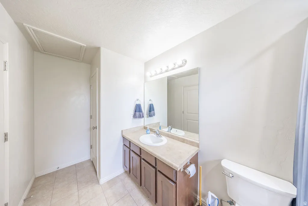 Primary bathroom featuring a single vanity with wood-finish cabinetry and a light-toned countertop