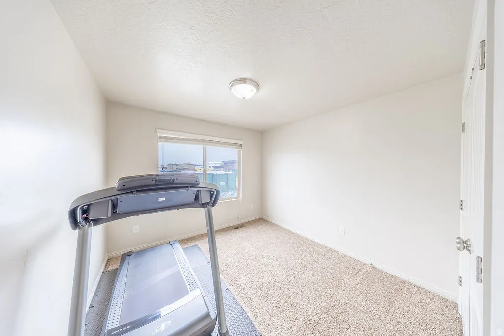 2nd bedroom featuring a single window with blinds, a flush-mount ceiling light fixture, and light-colored walls