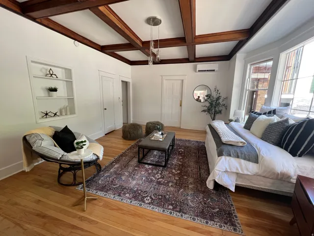 Living room with hardwood / wood-style floors, coffered ceiling, and built in features