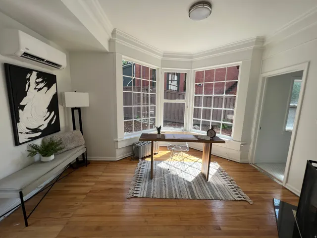 Office space with light wood-type flooring, crown molding, and radiator heating unit