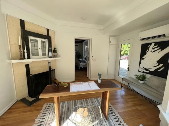 Interior space with a tile fireplace, wood finished floors, and crown molding