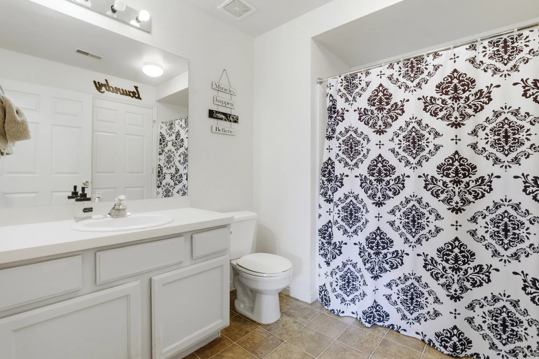 Full bathroom with vanity, a shower with curtain, and light tile patterned floors
