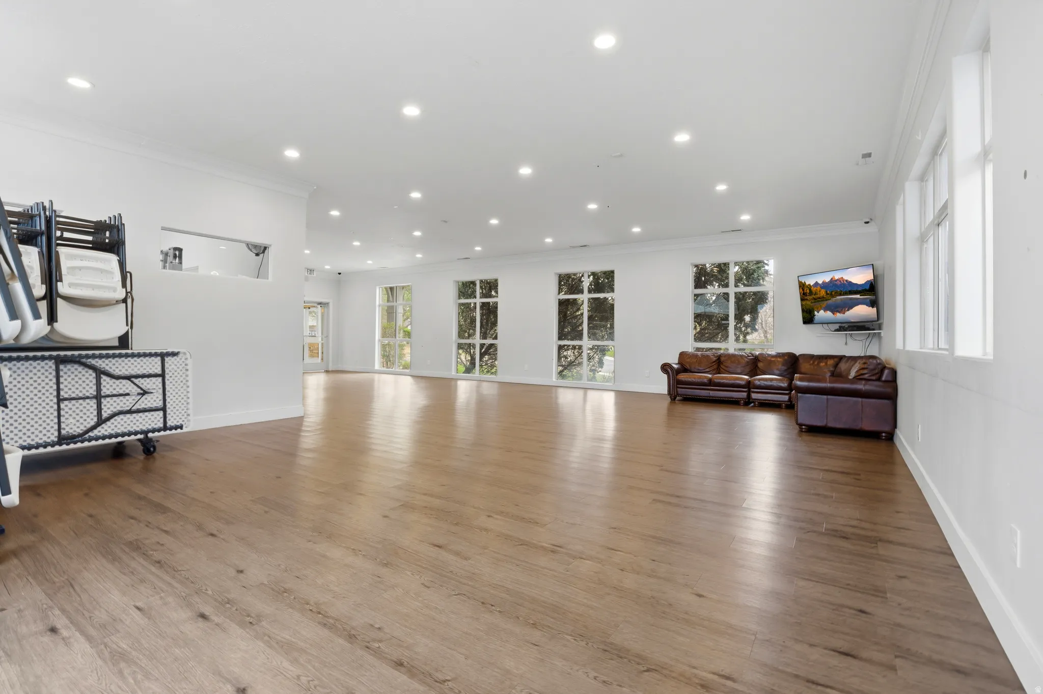 Living room with ornamental molding, wood finished floors, and recessed lighting