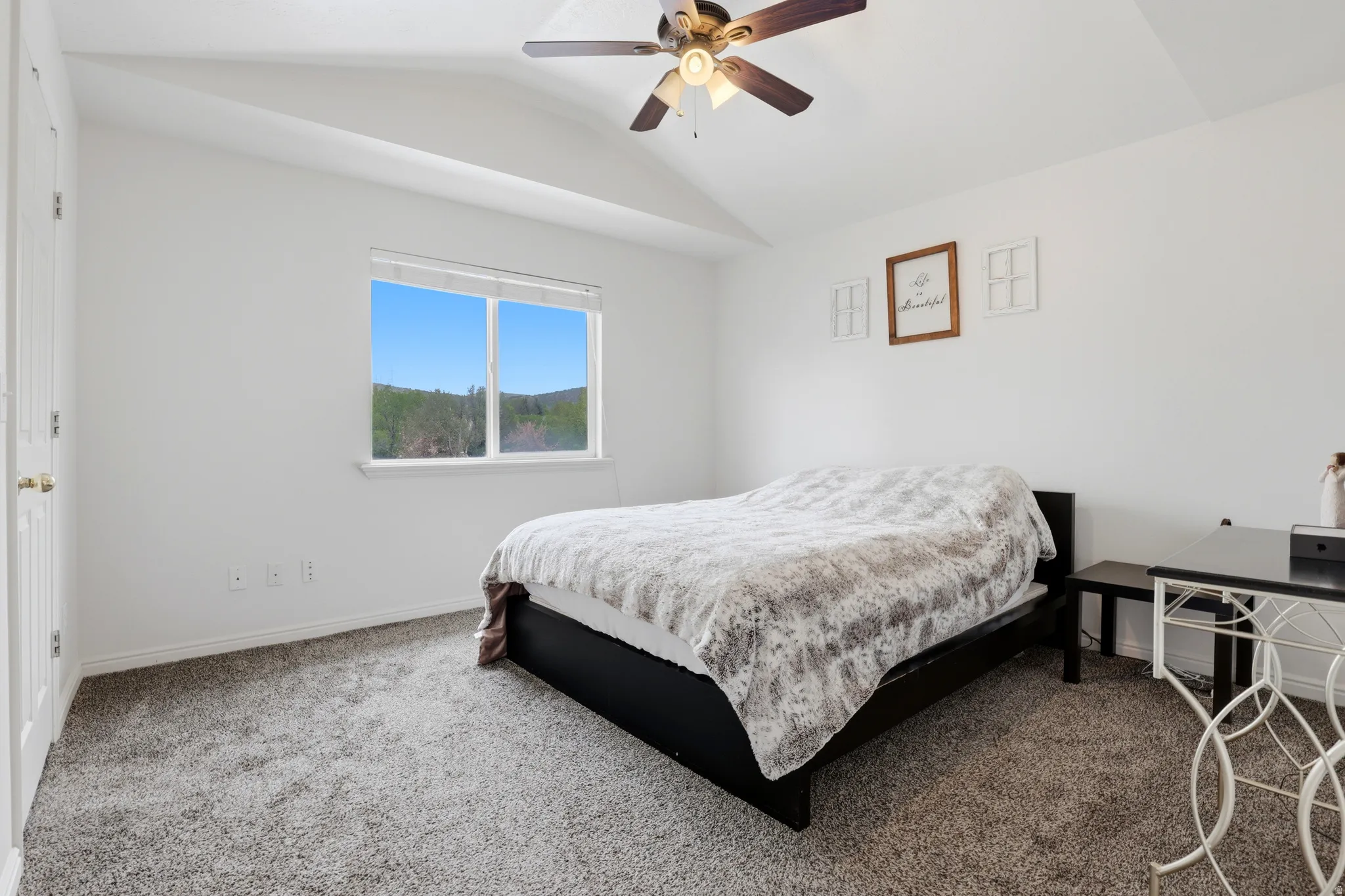 Bedroom with carpet flooring, vaulted ceiling, and ceiling fan