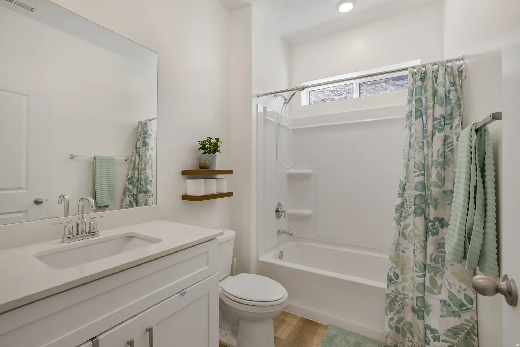 Bathroom with vanity, shower / bathtub combination with curtain, and light wood finished floors