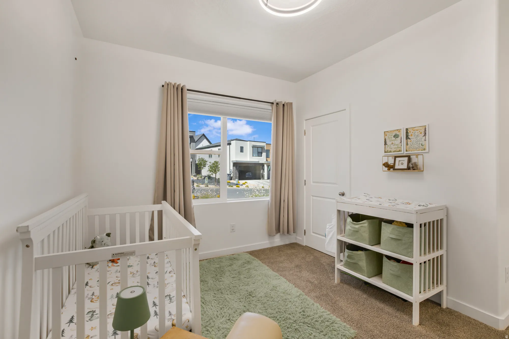 Carpeted bedroom with a nursery area and baseboards