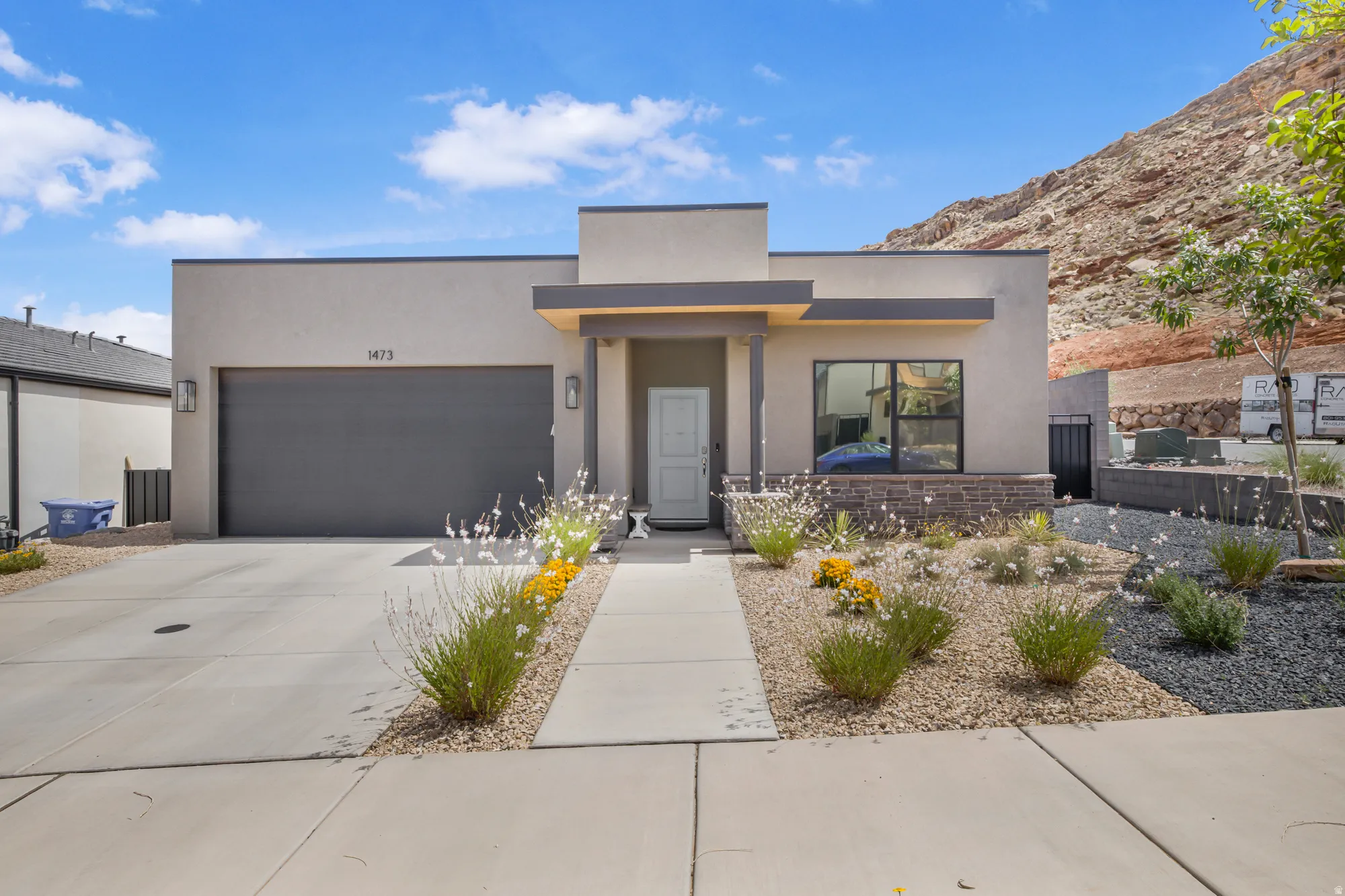 Modern home featuring an attached garage, stucco siding, and driveway