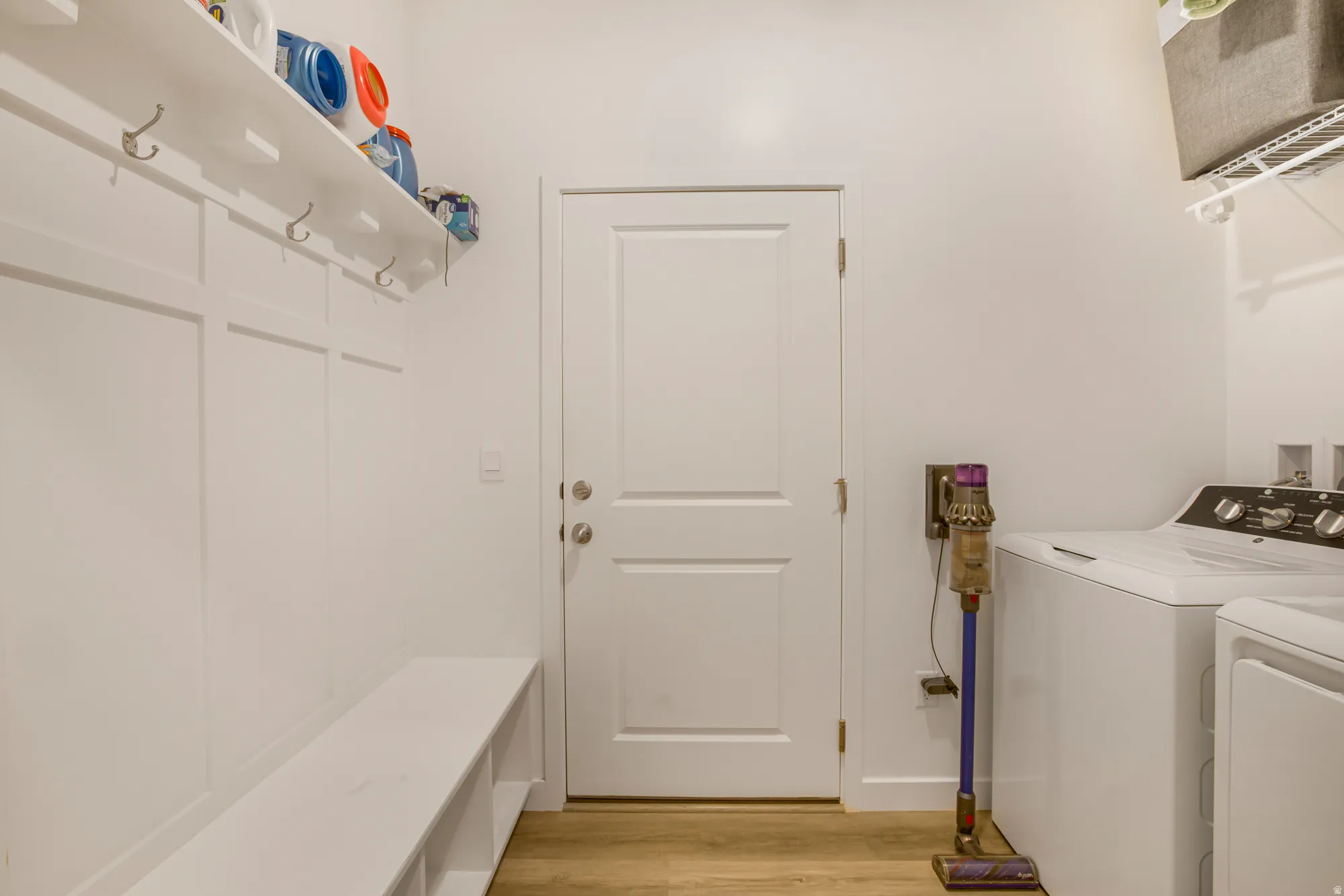 Laundry room with washer and dryer and light wood-style flooring