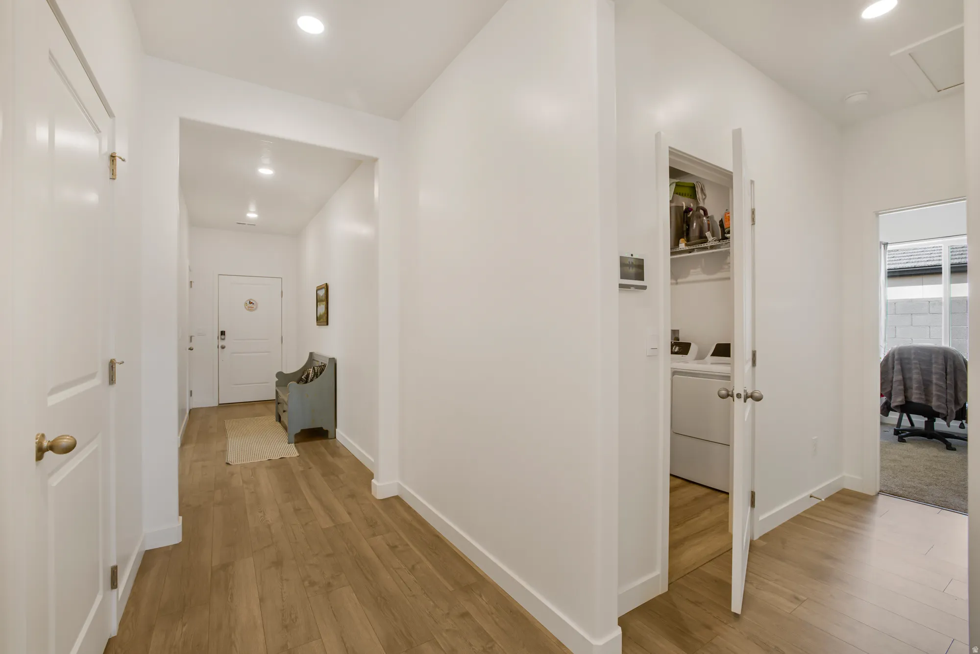 Hallway with light wood-style floors, recessed lighting, and independent washer and dryer