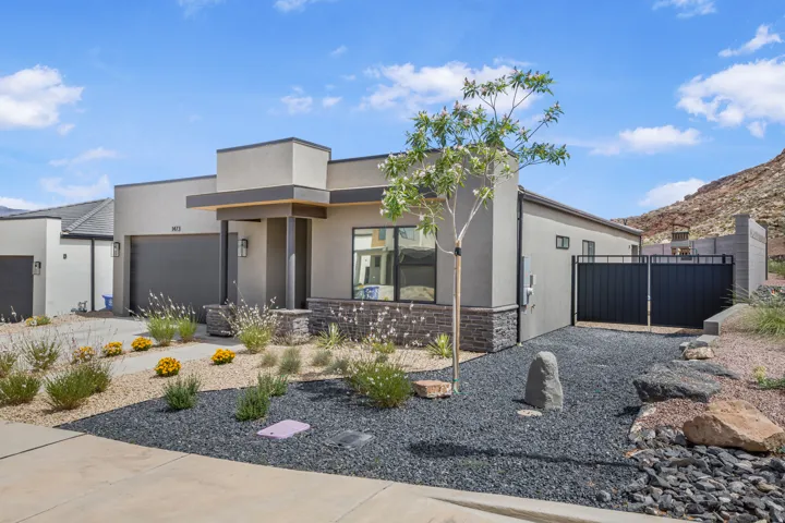 Contemporary home featuring stone siding, a garage, stucco siding, a porch, and driveway