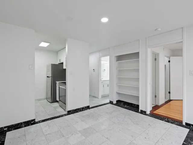 Kitchen with white cabinets, inlaid floor details, light countertops, stainless steel appliances, and recessed lighting
