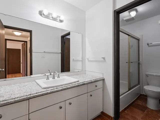 Full bathroom featuring vanity and enclosed tub / shower combo