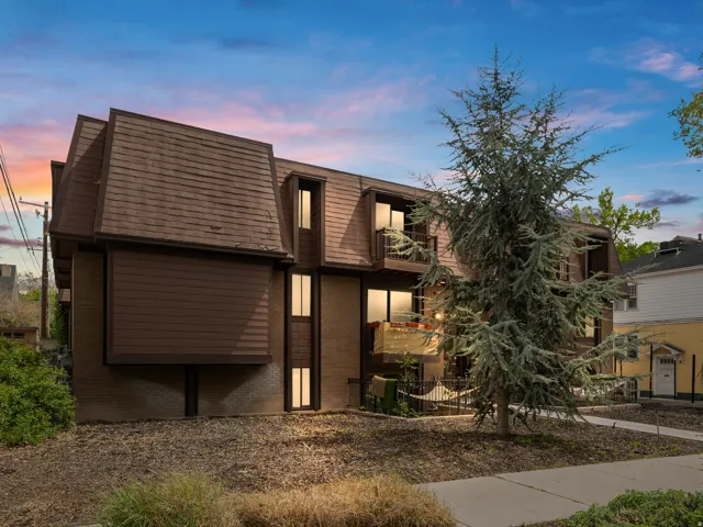 View of front of house featuring a balcony and brick siding