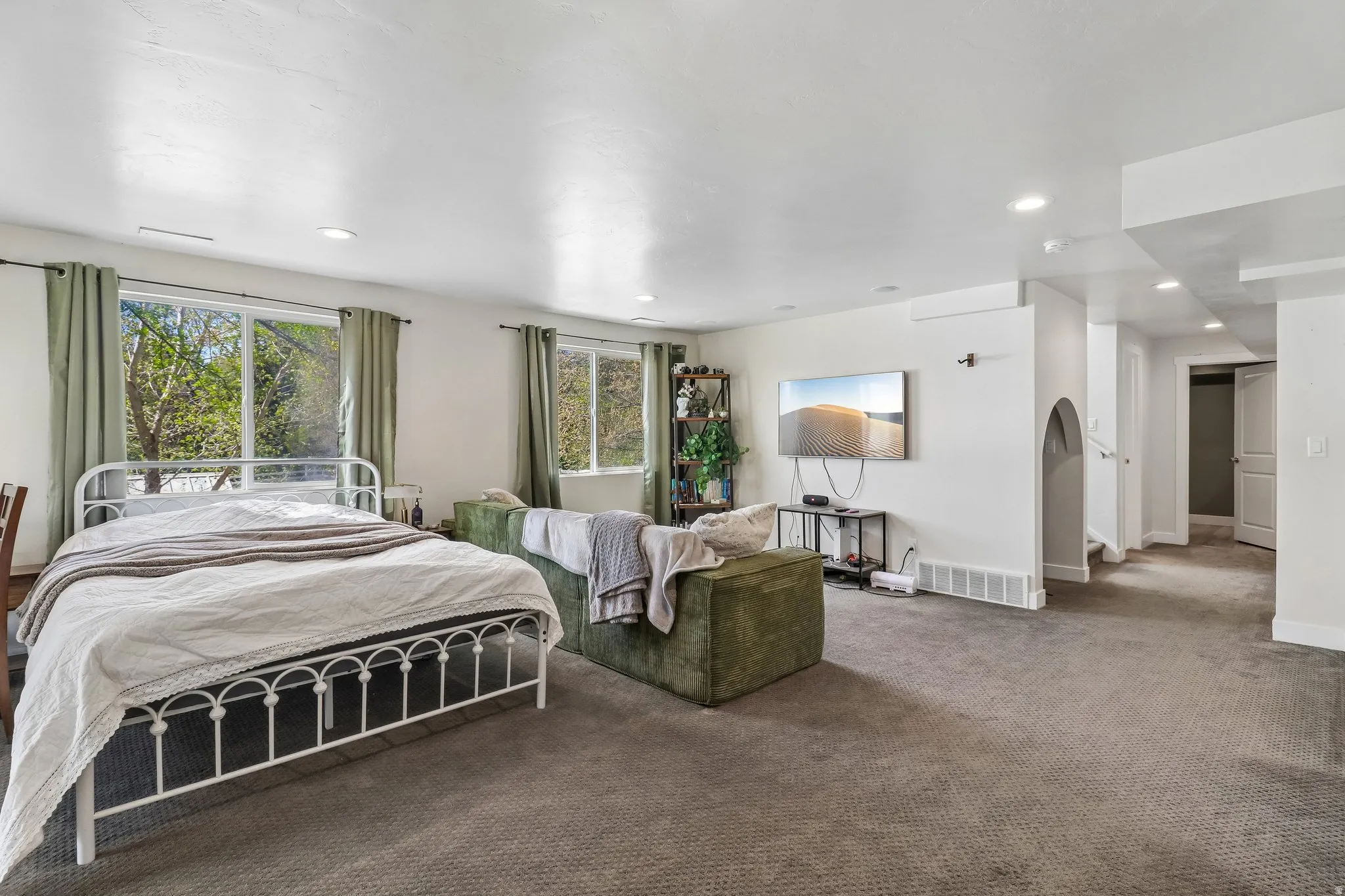 Carpeted bedroom with multiple windows and recessed lighting