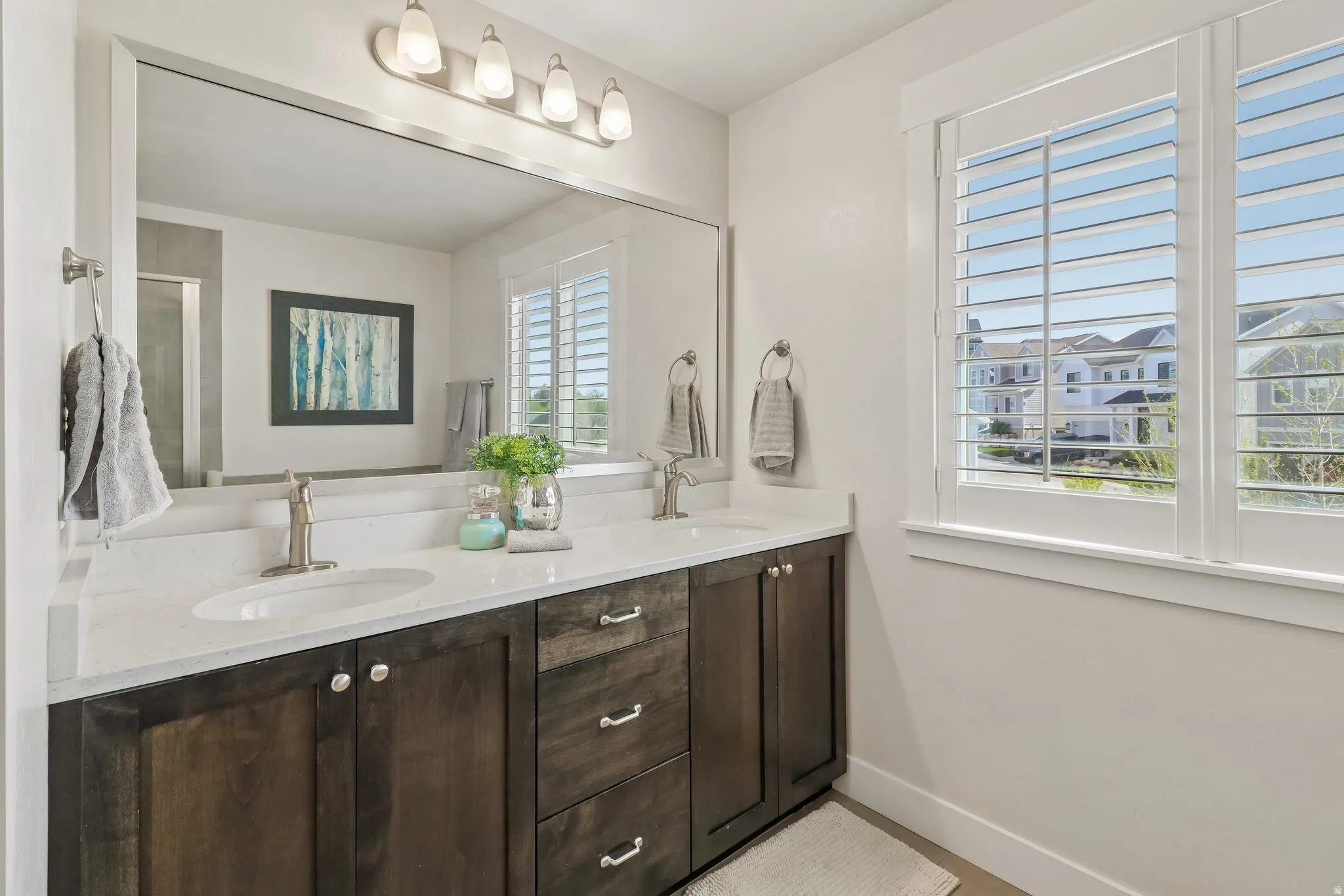 Bathroom with double vanity and baseboards
