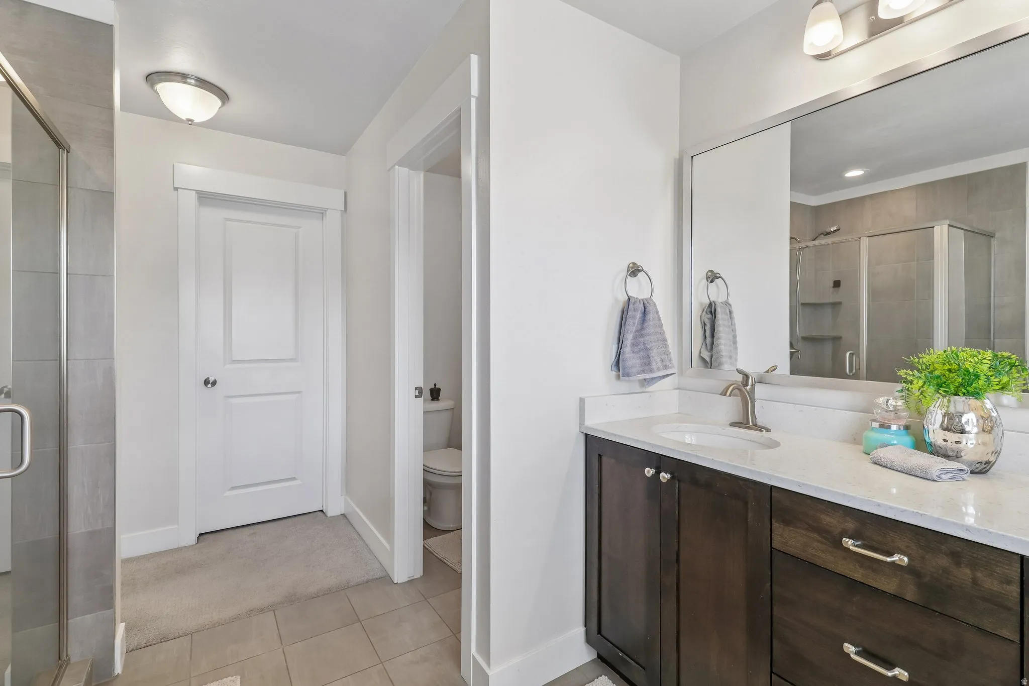 Bathroom with a stall shower, vanity, and light tile patterned flooring
