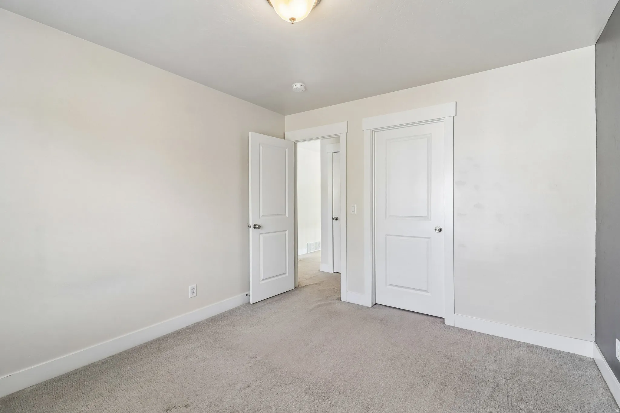Unfurnished bedroom with baseboards and light colored carpet