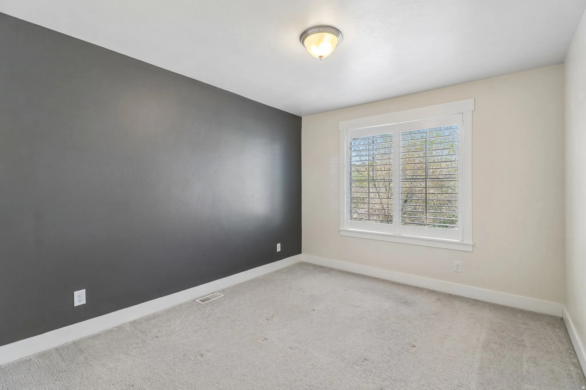 Spare room with baseboards and light colored carpet