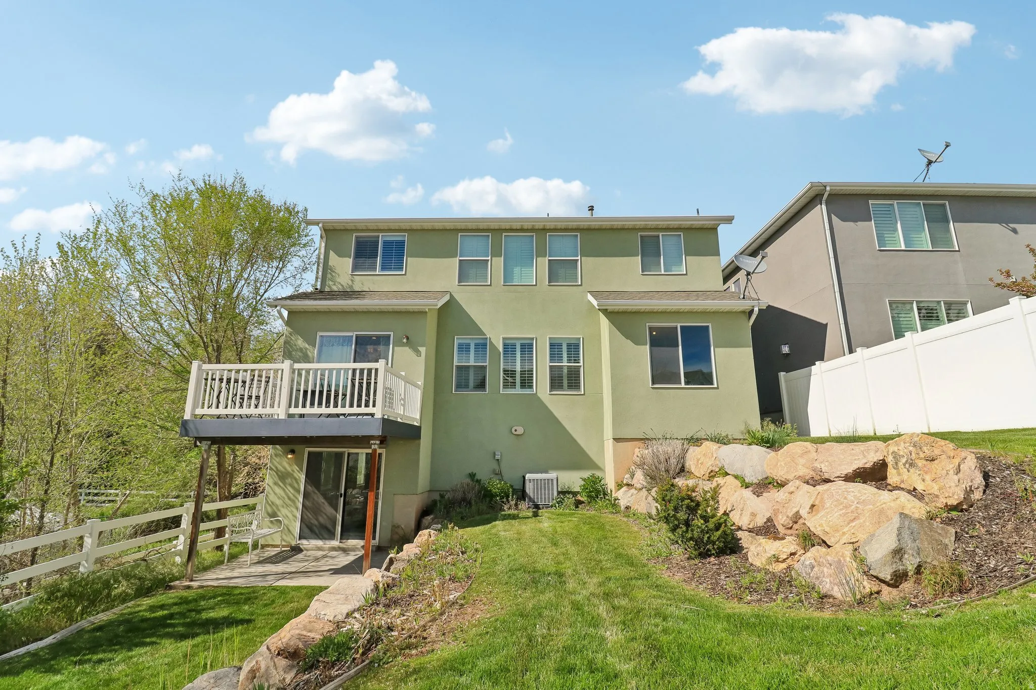 Back of house with stucco siding and a balcony