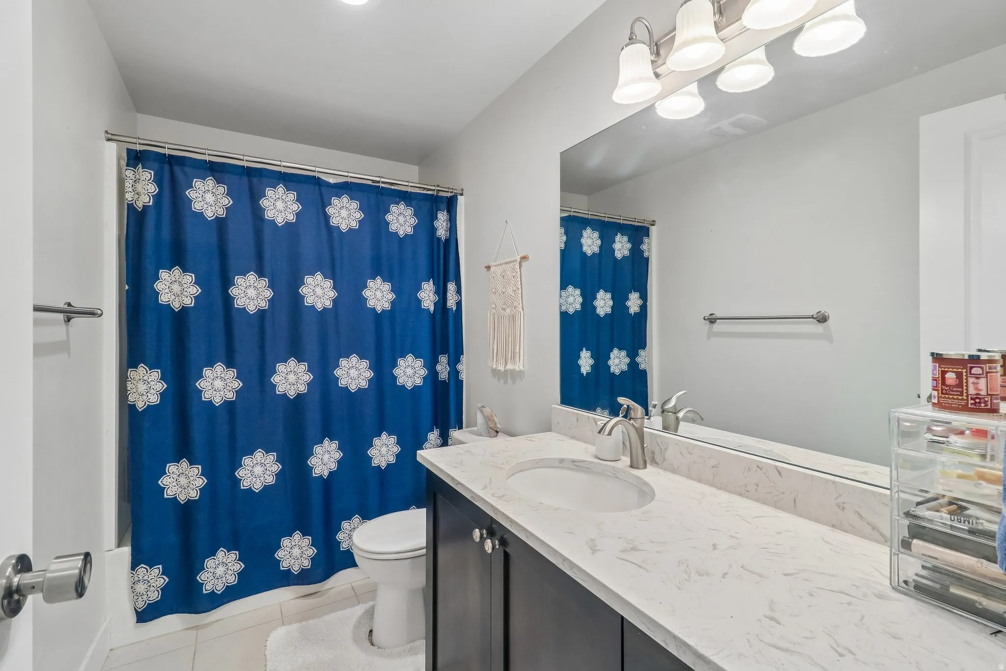 Full bathroom with vanity, light tile patterned flooring, and shower / bath combo