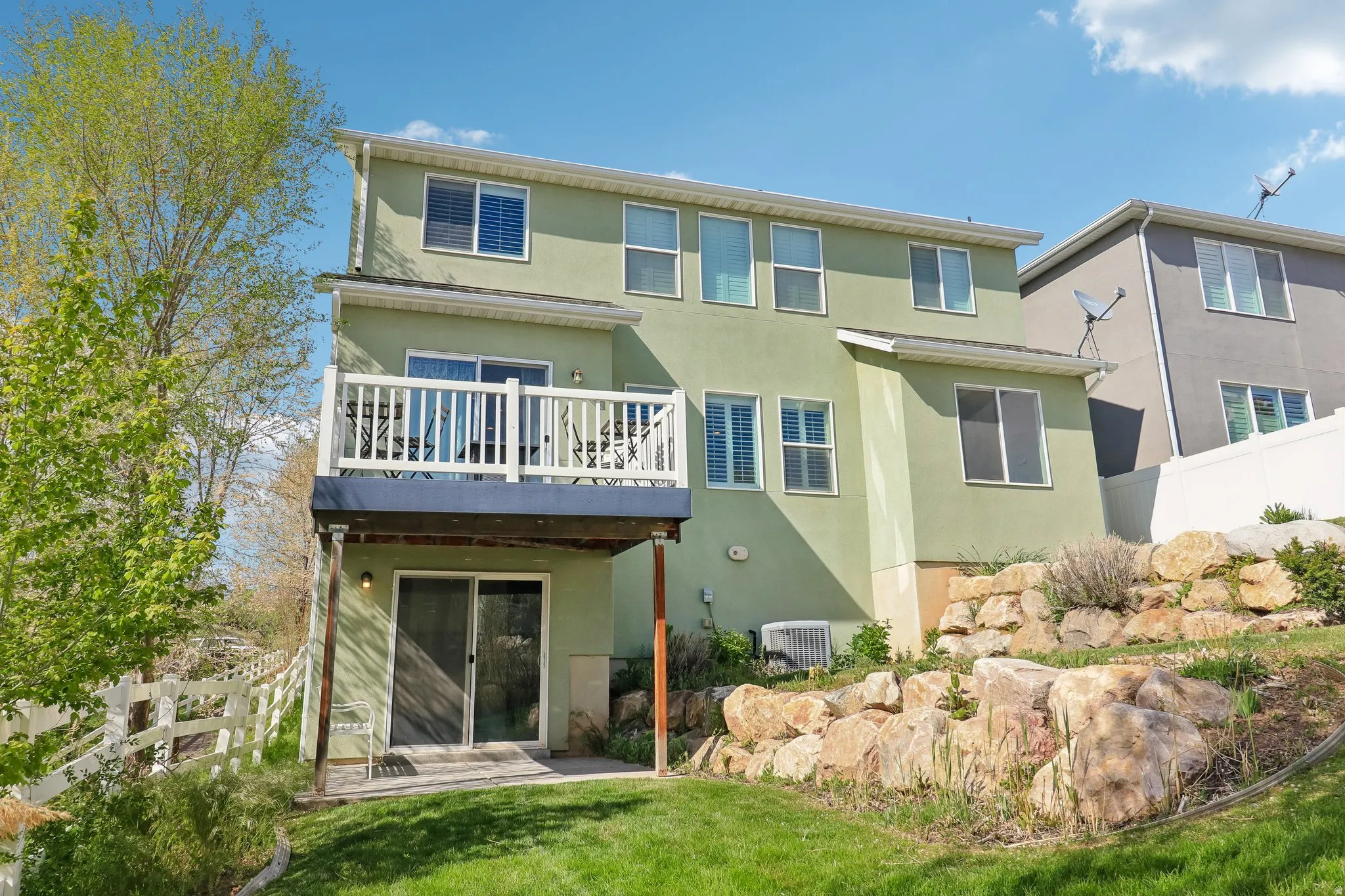 Rear view of house featuring stucco siding and a balcony
