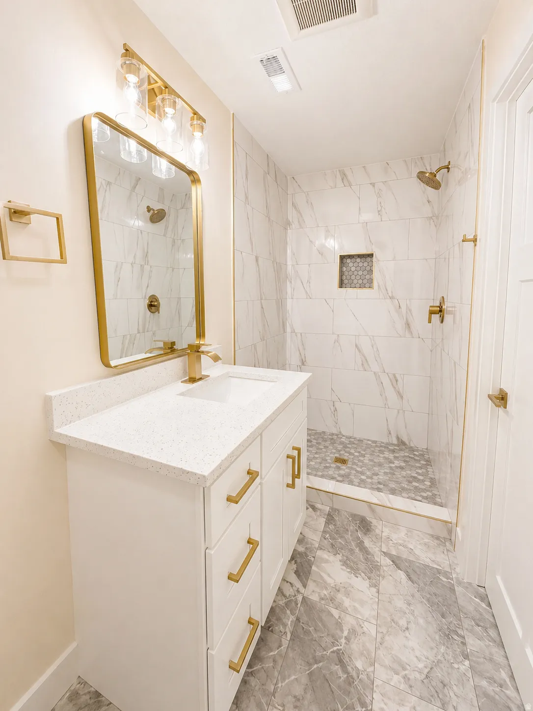 Bathroom featuring vanity, a marble finish shower, and light marble finish flooring