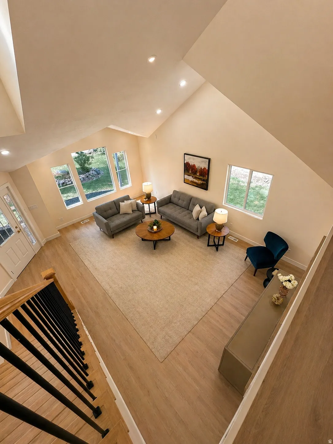 Living room with recessed lighting, wood finished floors, healthy amount of natural light, and vaulted ceiling