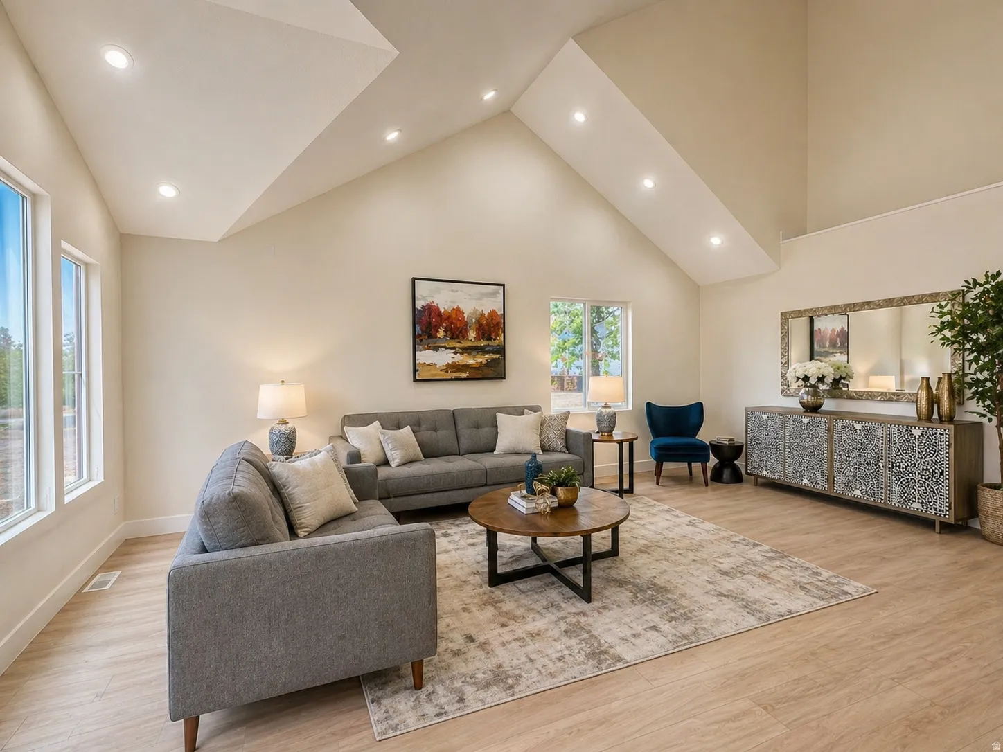 Living room with a high ceiling, recessed lighting, and light wood-type flooring