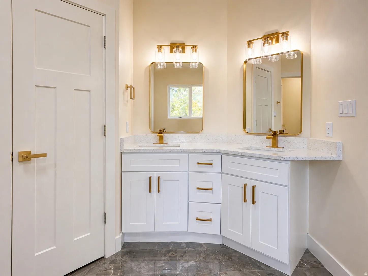 Bathroom with double vanity and dark marble finish flooring
