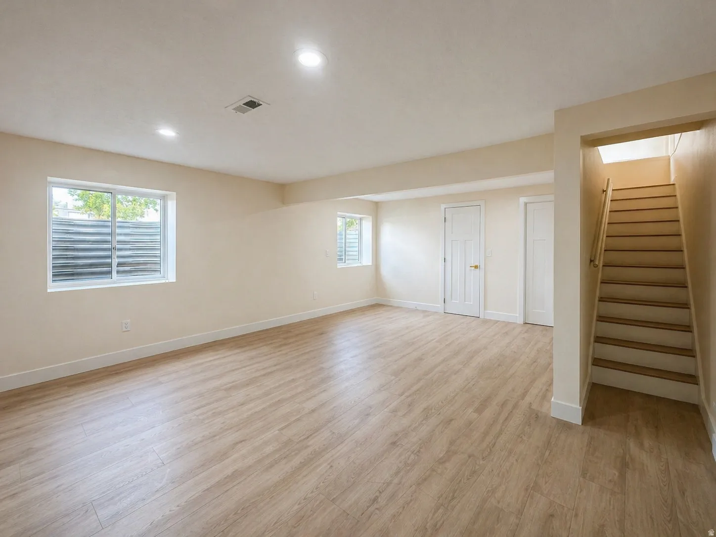 Basement with light wood-style flooring and recessed lighting