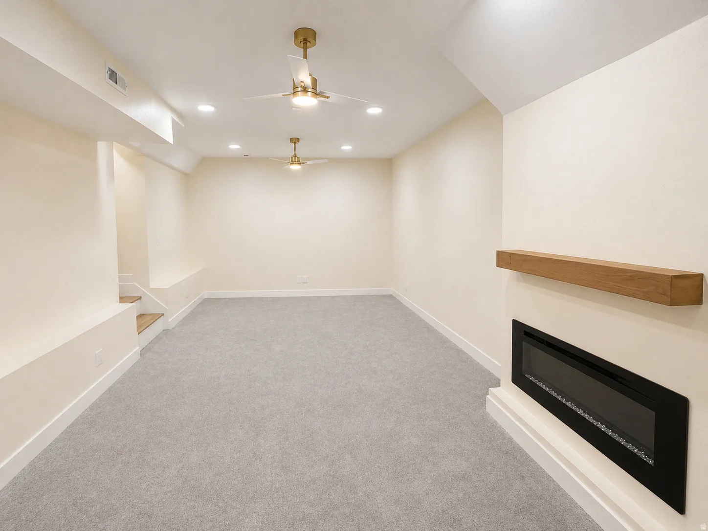 Unfurnished living room featuring ceiling fan, light colored carpet, recessed lighting, and a glass covered fireplace