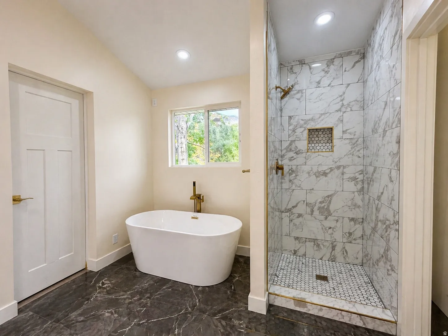 Full bath with a marble finish shower, marble look tile flooring, a soaking tub, and recessed lighting