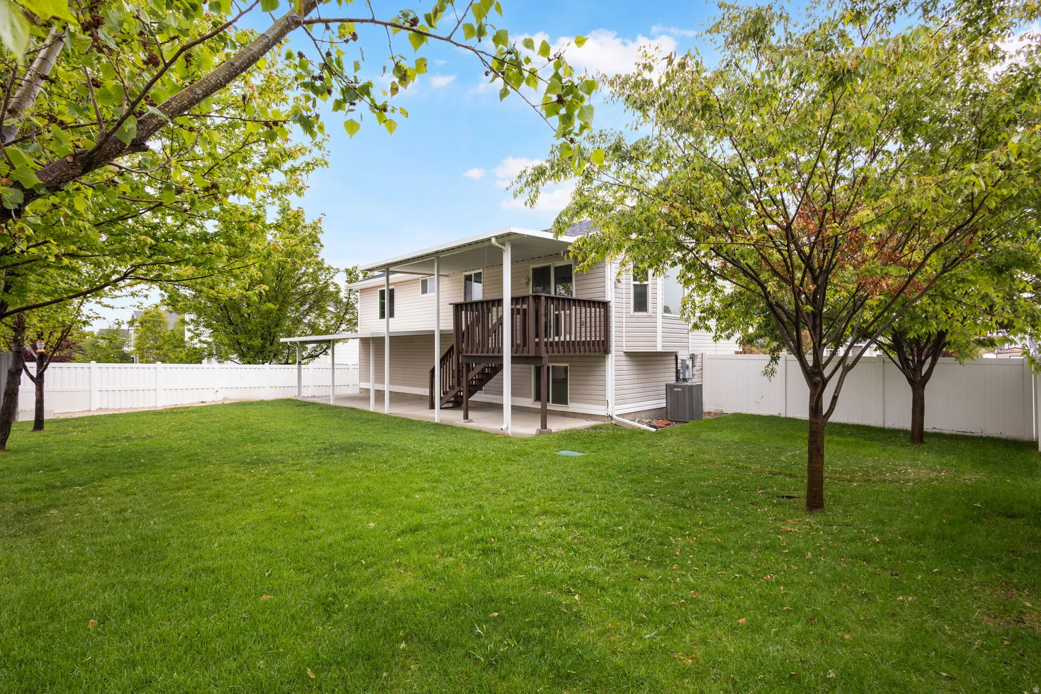 Rear view of property with a fenced backyard, a patio area, and a wooden deck