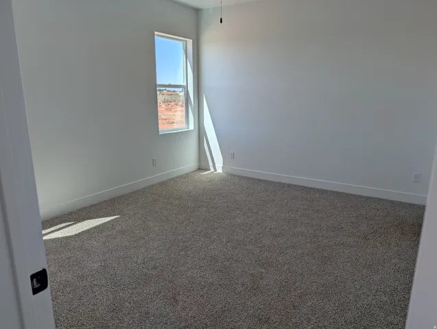 Neutral tone wall paint, contemporary baseboards, and plush carpeting