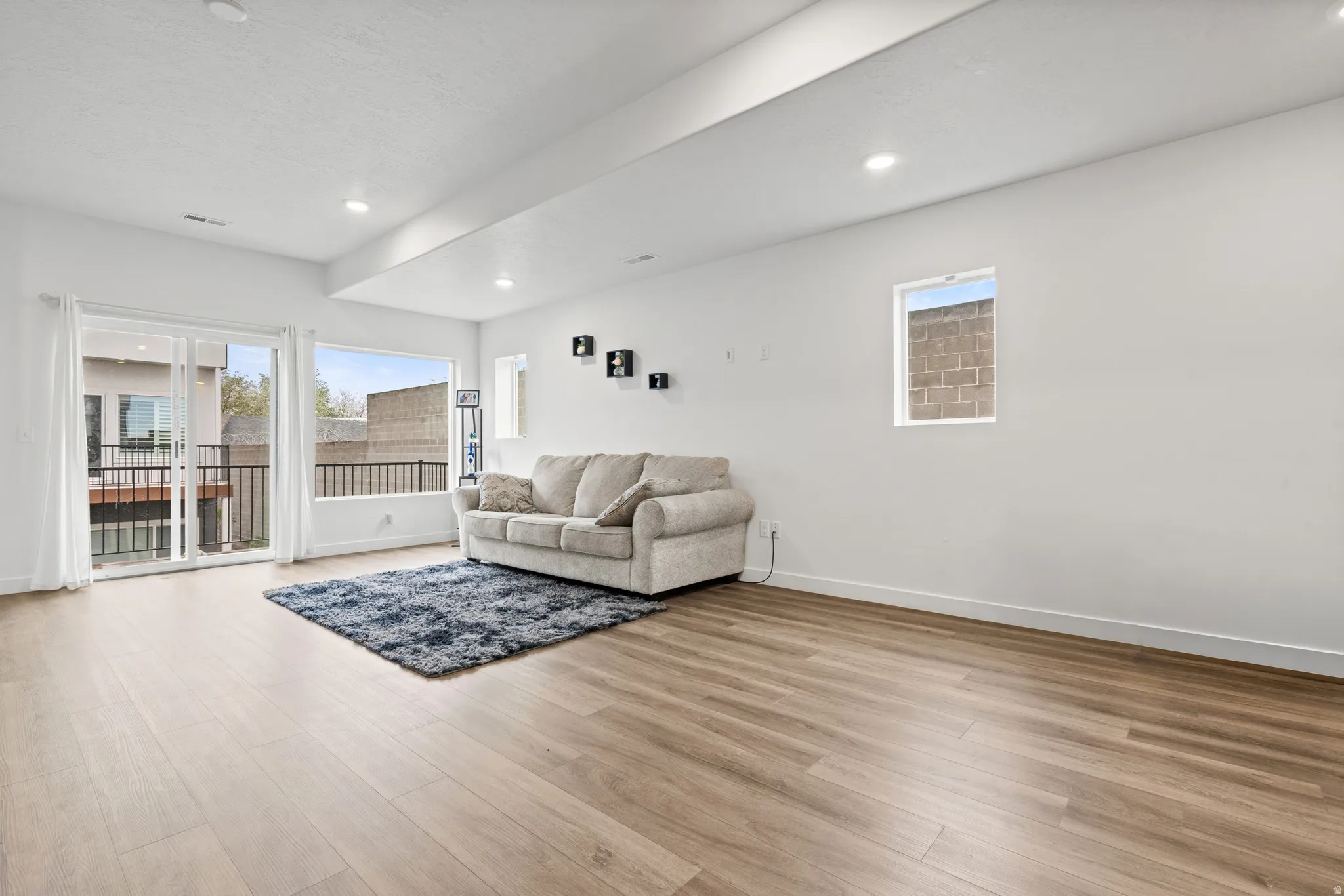 Living area with light wood-style flooring, healthy amount of natural light, and recessed lighting