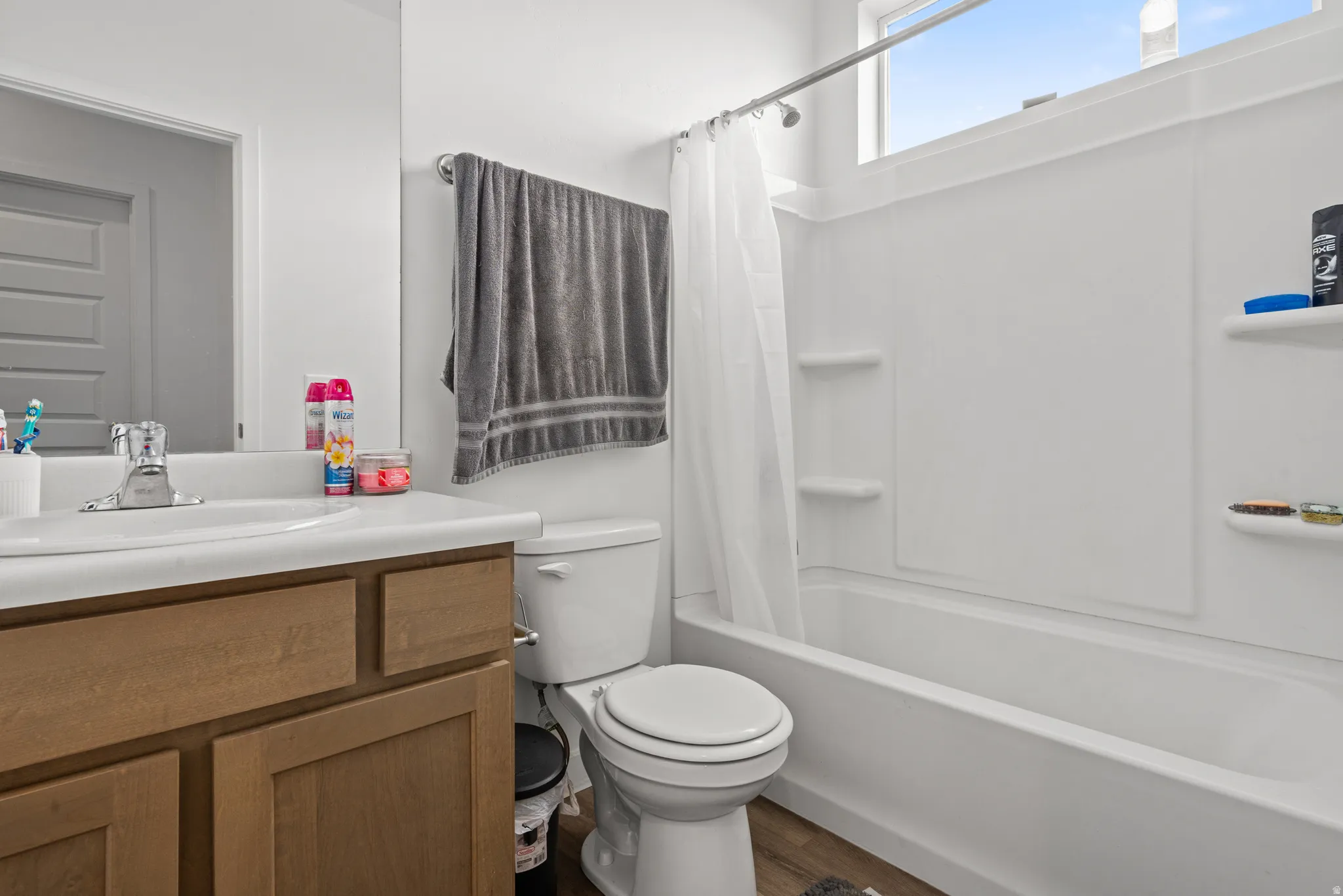 Bathroom with vanity, shower / tub combo, and dark wood-type flooring
