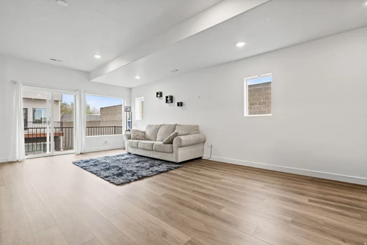 Living area with light wood-style flooring, healthy amount of natural light, and recessed lighting