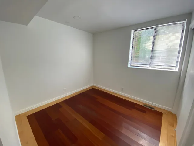 Spare room with hardwood / wood-style flooring and baseboards
