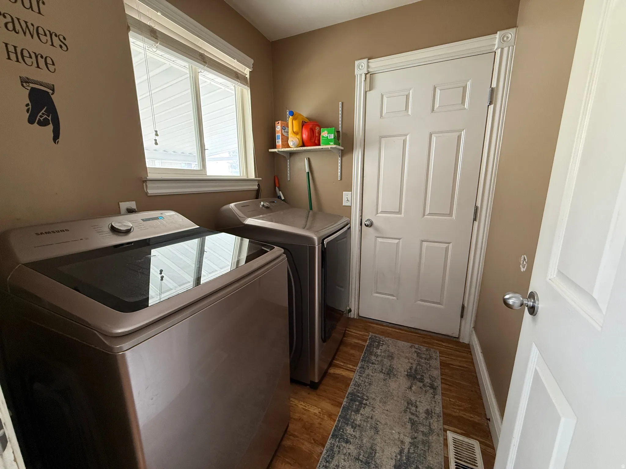 Laundry area with washer and dryer and dark wood-type flooring