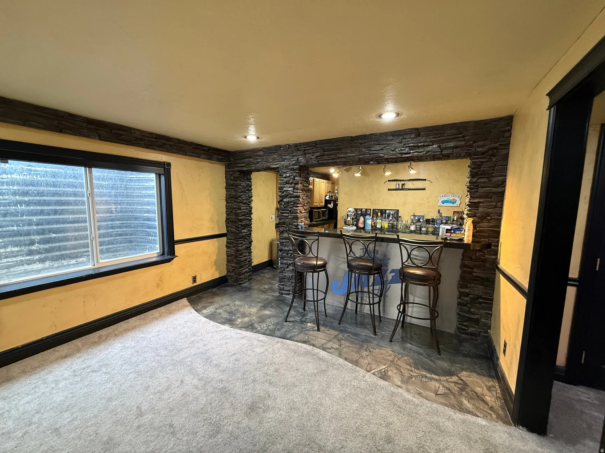 Indoor bar featuring dark countertops and baseboards