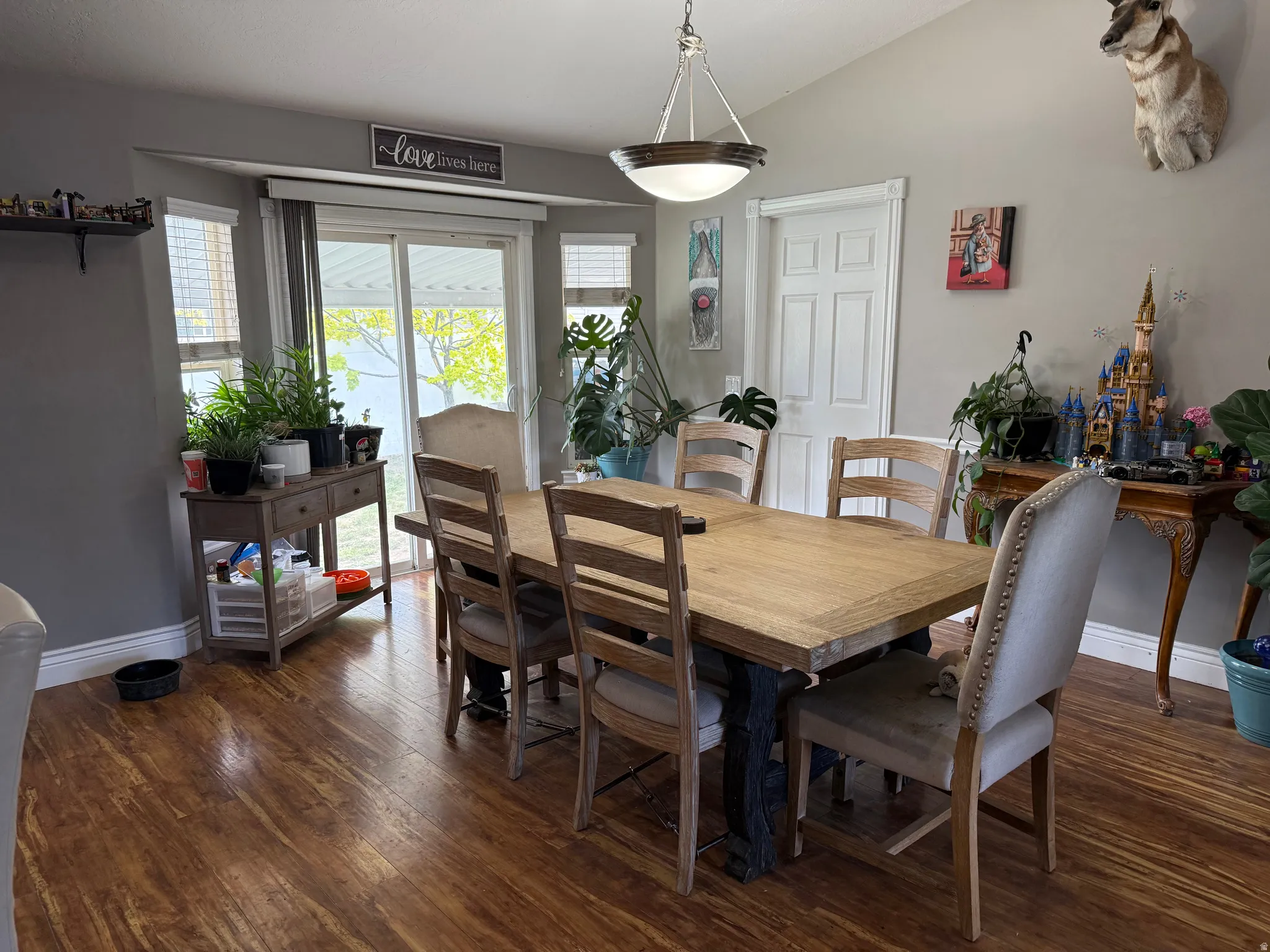 Dining room with vaulted ceiling and dark wood-type flooring