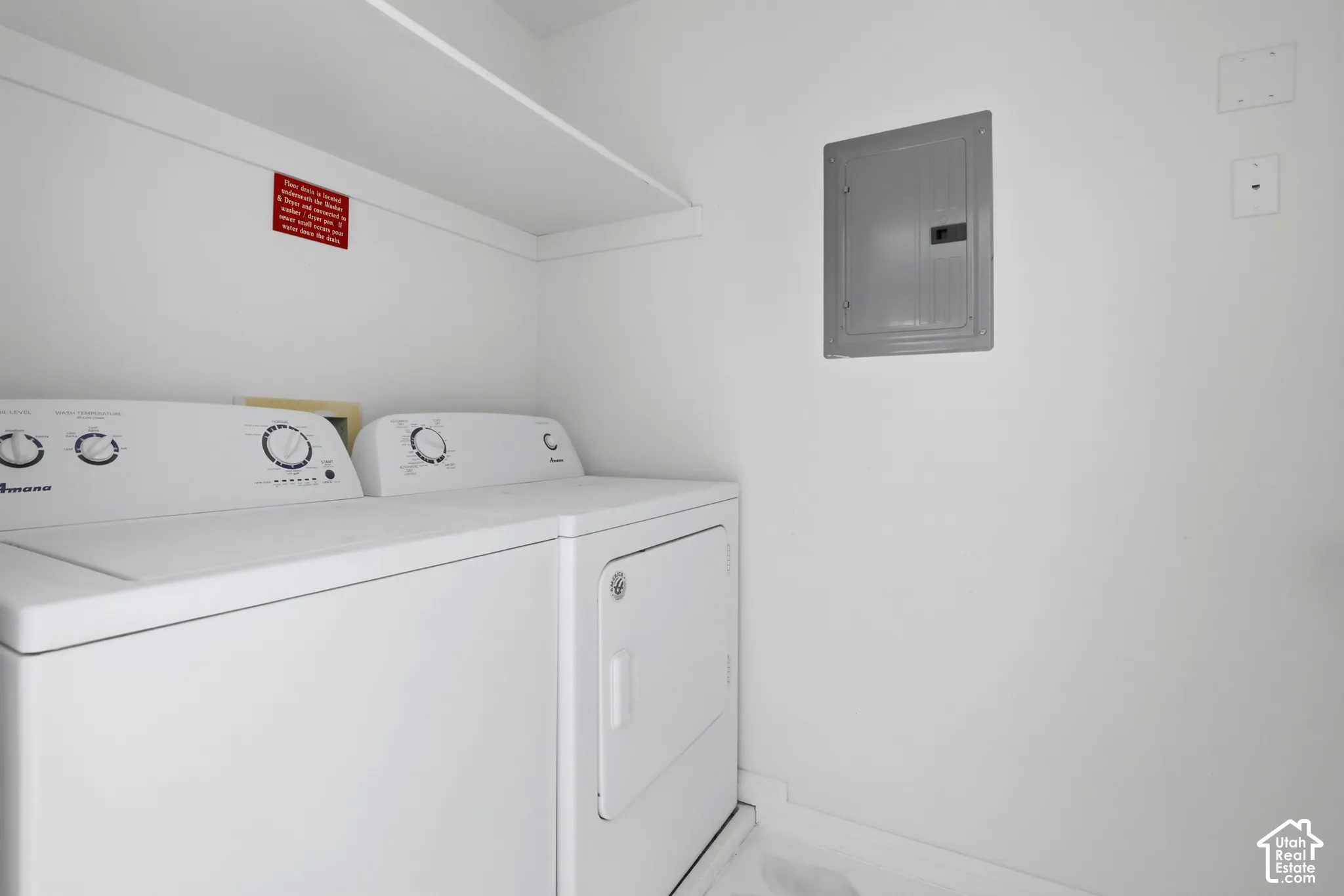 Dedicated laundry area featuring a white built-in storage shelf and a flush-mounted electrical service panel