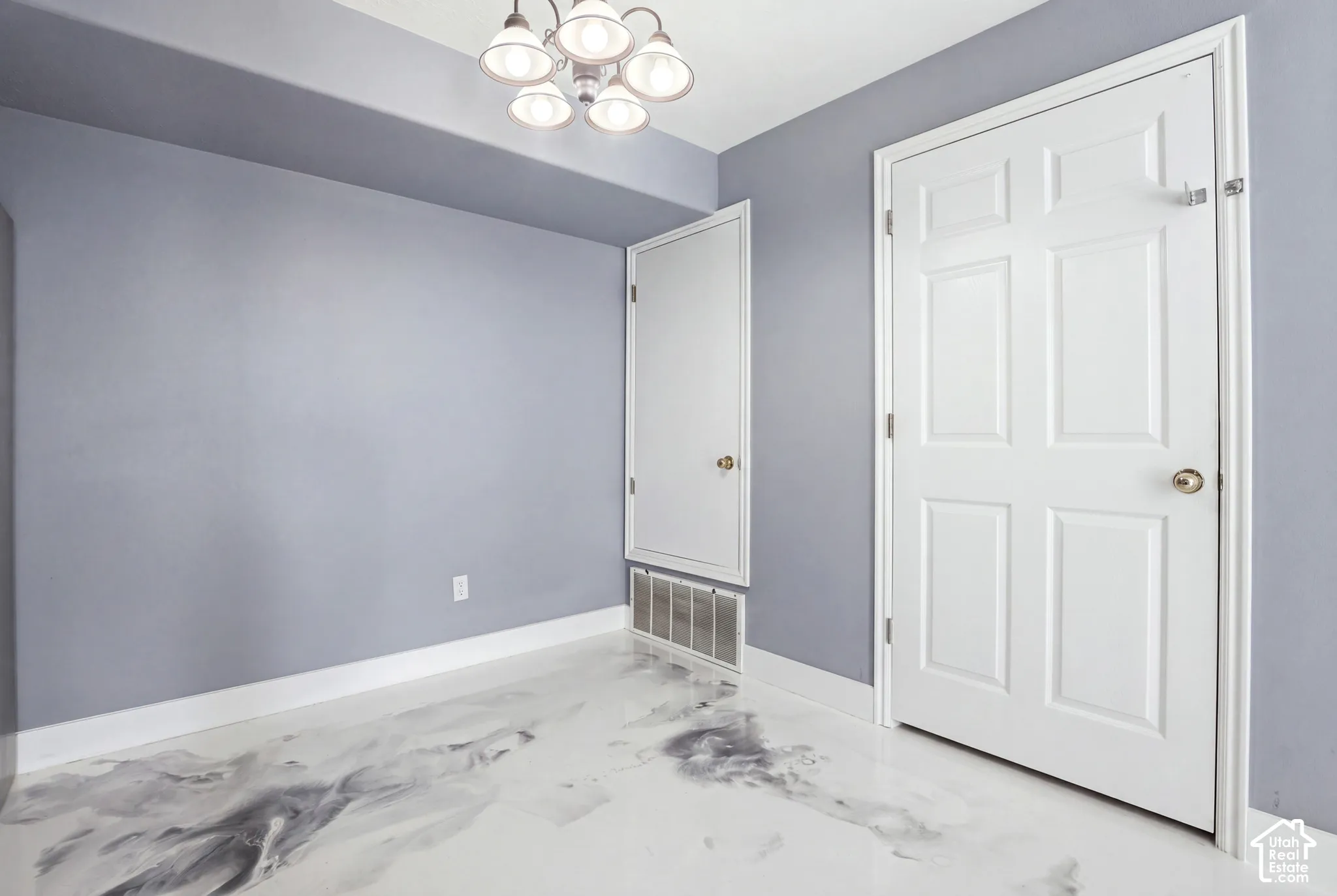 Glossy white marbleized resin flooring, neutral-toned walls, and a multi-light brushed nickel chandelier