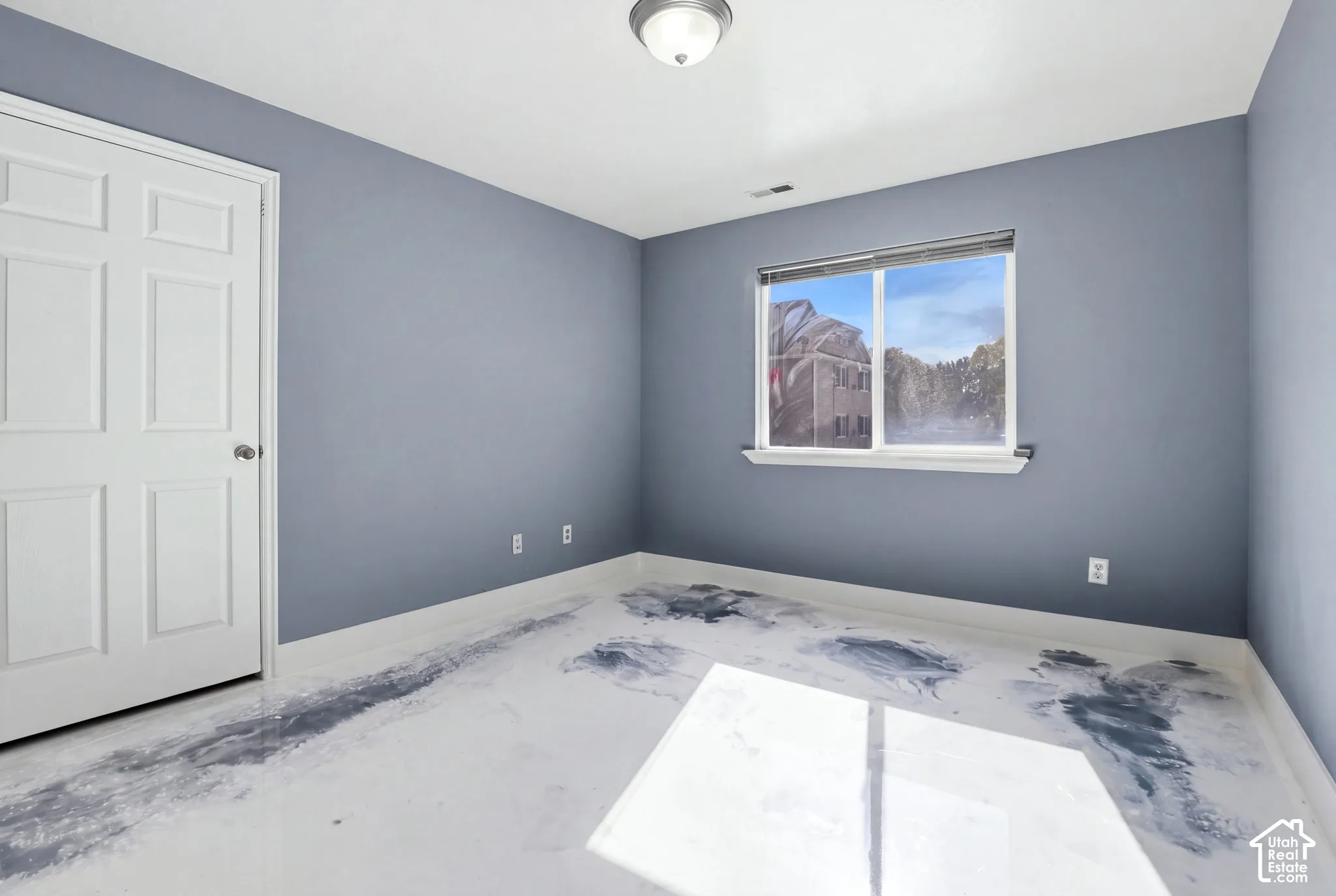 Interior room featuring blue-toned walls, a white multi-panel door, a single-hung window, and a glossy, marbled-finish floor